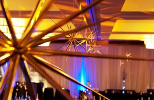 Spiked Stars hang from the ceiling and rest upon tables for this corporate holiday party.