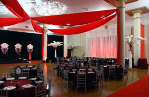 Red ceiling drape, fanned columns, and white palm trees